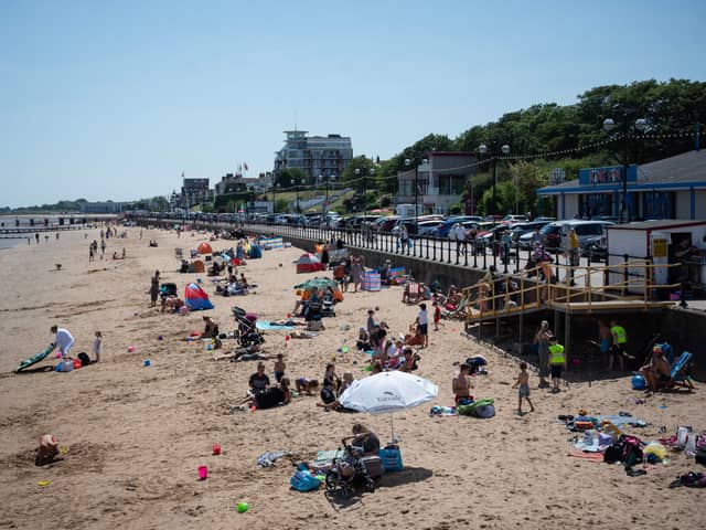 Members of the public relax on the beach in hot weather in Cleethorpes, north east England.