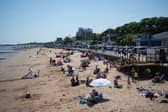 Members of the public relax on the beach in hot weather in Cleethorpes, north east England.