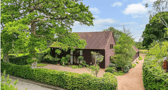 The listing says: "With a perfect combination of charm and character, as well a layout that offers both versatility and flexibility for any growing family, Clarendon Barn is surrounded by countryside and comes with approaching one and a half acres of mature gardens with two adjoining paddocks." 