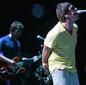 Liam (R) and Noel Gallagher perform on stage. Photo: JOSE JORDAN/AFP via Getty Images