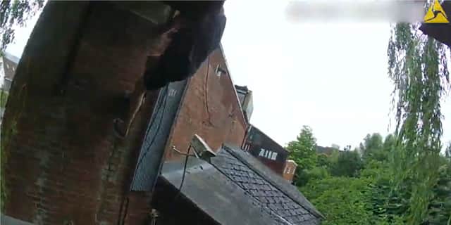 Aleks Sinaj attempts to scale down the building.