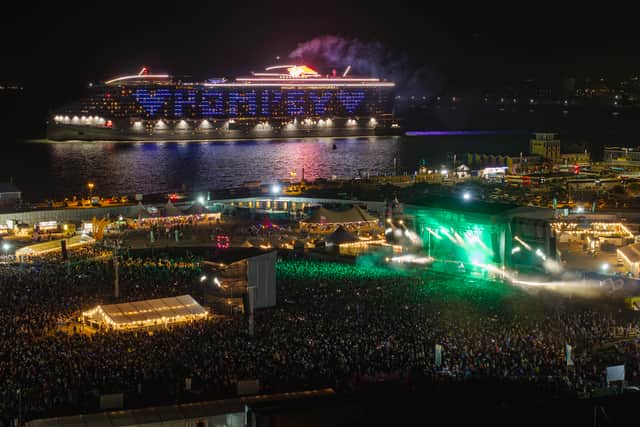 Resilient Lady, operated by Virgin Voyages, sailing past Portsmouth during Victorious Festival 2024, with an illuminated messages "Pompey" seen by festival-goers.