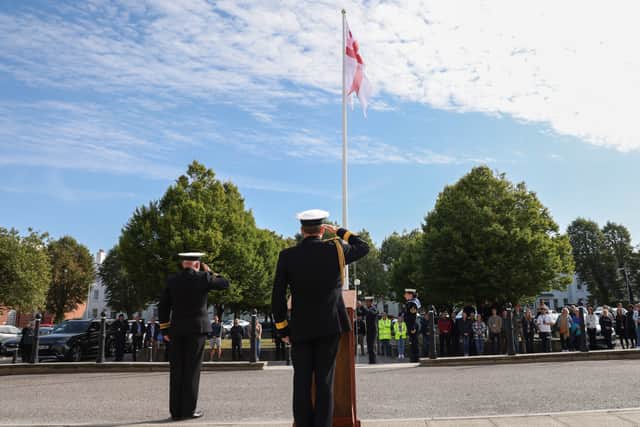 The flag raising ceremony near the Victory Building at HMNB Portsmouth.