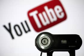 File photo of a camera positioned in front of YouTube's logo. Photo: LIONEL BONAVENTURE/AFP via Getty Images