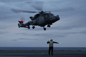 A pilot stationed on HMS Queen Elizabeth saved six lives after carrying out an emergency landing during a medical evacuation.