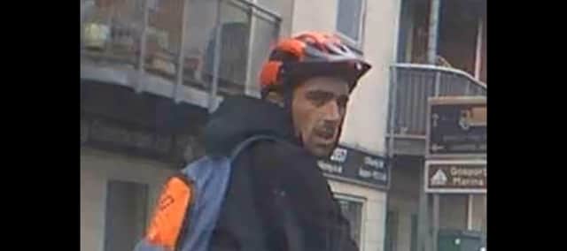 Police have released the image of a man they want to speak to after a cyclist punched the bonnet and windscreen of a car
