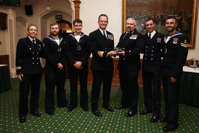A helicopter crew that destroyed several drones operated by Houthi rebels were honoured at a Royal Navy awards evening. They were deployed with Portsmouth-based warship HMS Diamond in the Red Sea. Pictured are Vengeance 4 Flight receive the Sopwith Pup Trophy from Rear Admiral Anthony Rimmington.