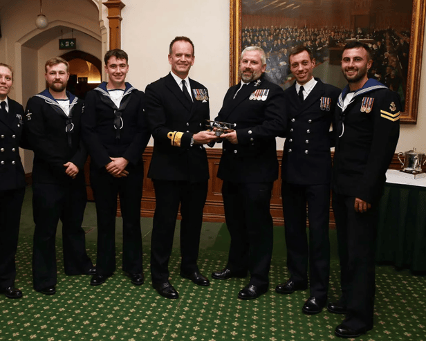 A helicopter crew that destroyed several drones operated by Houthi rebels were honoured at a Royal Navy awards evening. They were deployed with Portsmouth-based warship HMS Diamond in the Red Sea. Pictured are Vengeance 4 Flight receive the Sopwith Pup Trophy from Rear Admiral Anthony Rimmington.