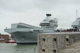 HMS Queen Elizabeth leaving Portsmouth on October 21, 2024, as crowds gather at The Round Tower in Old Portsmouth and along The Hot Walls to watch the aircraft carrier leave.