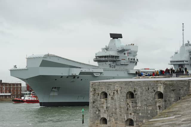 HMS Queen Elizabeth leaving Portsmouth on October 21, 2024, as crowds gather at The Round Tower in Old Portsmouth and along The Hot Walls to watch the aircraft carrier leave.