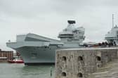 HMS Queen Elizabeth leaving Portsmouth on October 21, 2024, as crowds gather at The Round Tower in Old Portsmouth and along The Hot Walls to watch the aircraft carrier leave.