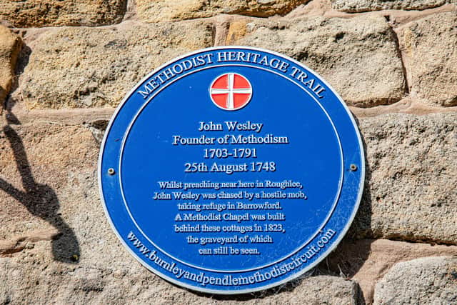 A blue plaque on the front of Waterfall Cottage. Bob Sutton and Nubia have a 200 year old grave in the back garden of their cottage in Roughlee, Lancashire.