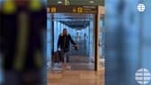 Passenger wades through flood water at Barcelona's El Prat airport.