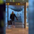 Passenger wades through flood water at Barcelona's El Prat airport.