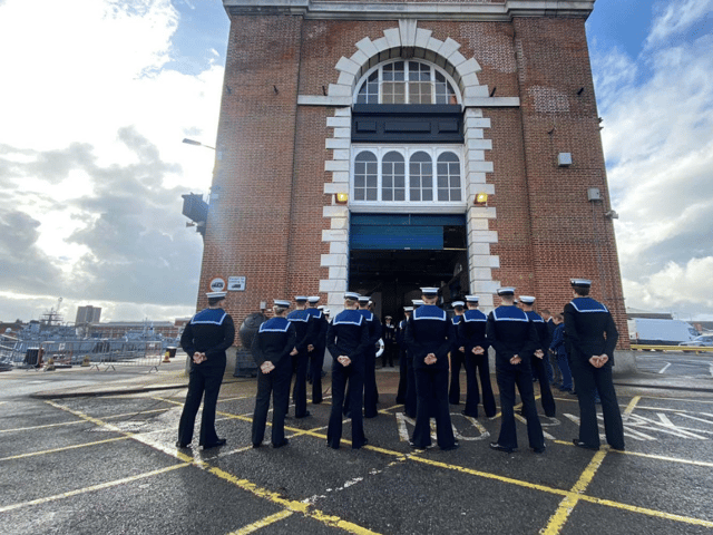 The Royal Navy has disbanded an autonomous systems testing team based in Portsmouth. Pictured are the unit bringing down the White Ensign flag.