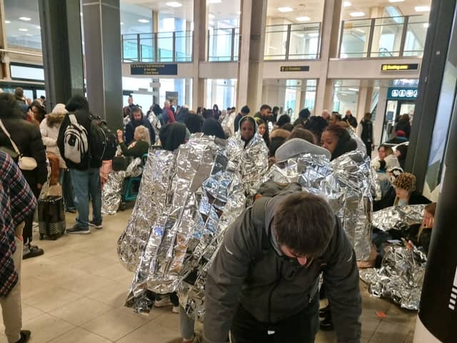 Evacuated Gatwick Airport passengers wrap themselves in foil blankets.