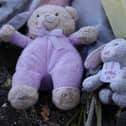 Flowers and stuffed toys are left as tributes to 'Baby A'.