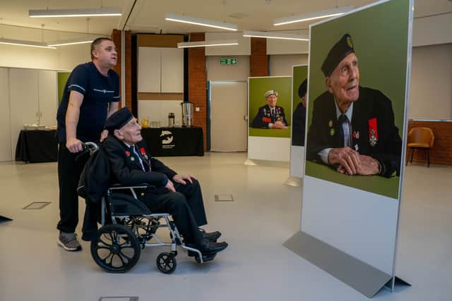 The exhibition, The Lucky Ones Grow Old, features portraits of veterans by Matt Sills taken at The D-Day Story on Wednesday 18th December 2024. Pictured: John Dennett looking at his exhibition portrait. Picture: Habibur Rahman