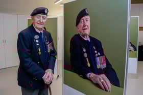 The exhibition, The Lucky Ones Grow Old, features portraits of veterans by Matt Sills taken at The D-Day Story on Wednesday 18th December 2024. Pictured: Cyril Stanley (Stan) Ford alongside his portrait. Picture: Habibur Rahman.