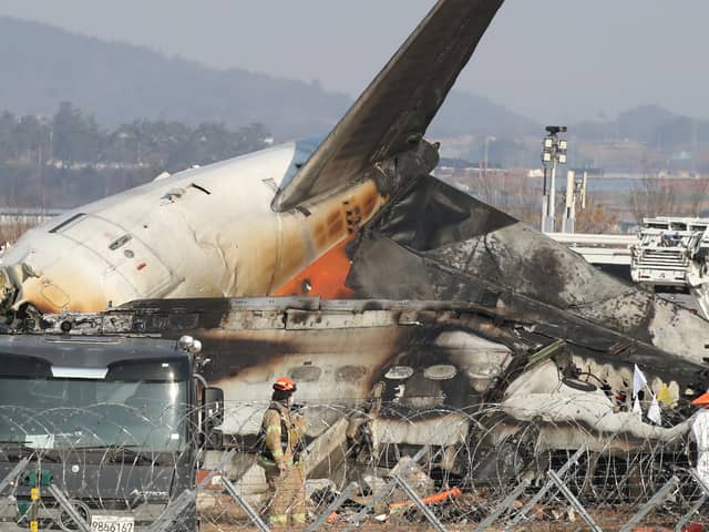 Firefighters check near the wreckage of a passenger plane at Muan International Airport 