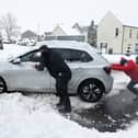 Stock image of car being pushed out of snow.