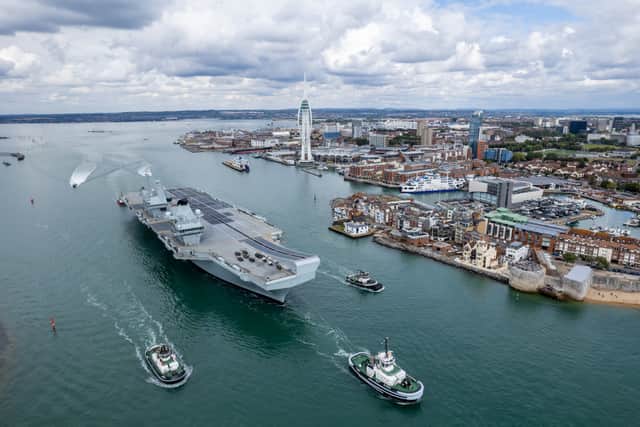 Pictured: HMS Prince of Wales leaving Portsmouth Harbour with a tug escort.