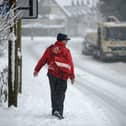 A postman makes his way through the snow.