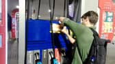Dr Patrick Hart cracks the display panels of petrol pumps at Esso Thurrock Services on the M25 on August 24 2022. 