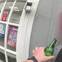 Man tries to take swig of his lager while being arrested for drink driving.