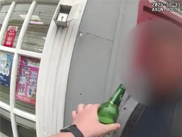 Man tries to take swig of his lager while being arrested for drink driving.