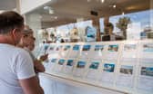 Tourists look at apartments in the window shop of a real estate on the island of Ibiza (Photo: JAIME REINA/AFP via Getty Images)