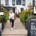 Former England rugby international Danny Care kicking a ball "into space" from outside the Greene King sport pub The Barmy Arms in Twickenham