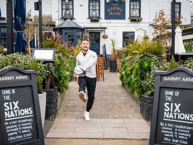 Former England rugby international Danny Care kicking a ball "into space" from outside the Greene King sport pub The Barmy Arms in Twickenham