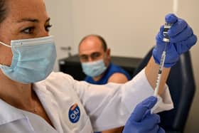 A nurse prepares to give a patient the mpox vaccine. 