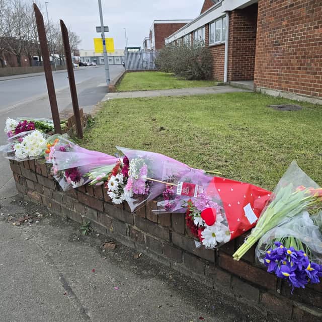 Flowers have been left at the scene where a woman in her 20s died after being hit a lorry yesterday morning.