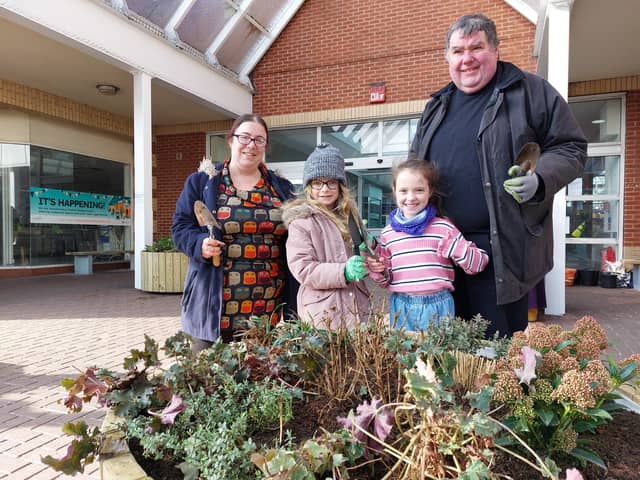 Councillor Kimberley Barrett and Reverend Canon Bob White help local children fill the new planters with shrubs outside The Bridge Centre in Fratton.