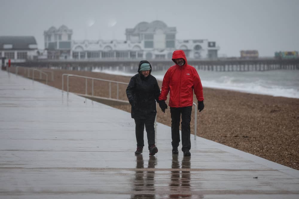 A couple walk in heavy rain on the South Parade Pier, in Portsmouth.