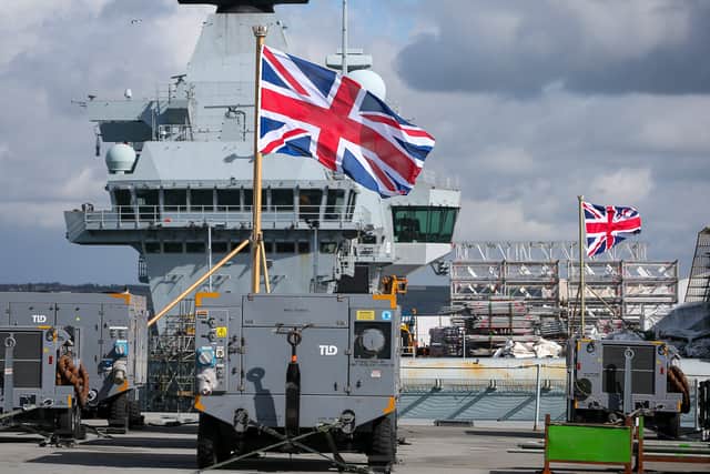 Union Jacks with HMS Queen Elizabeth behind. Last-minute preparations are taking place on HMS Prince of Wales for the upcoming UKCSG.