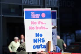 Protestors gathered outside QA Hospital to protest potential job cuts.