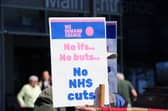 Protestors gathered outside QA Hospital to protest potential job cuts.