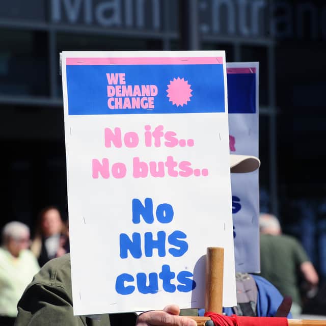 Protestors gathered outside QA Hospital to protest potential job cuts.