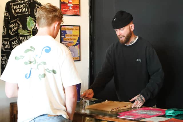 Merlin Pitt, owner of Actually Merlin Vintage, selling clothes at his store on Albert Road, Southsea. 