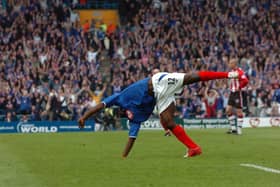 Lomana LuaLua does his iconic backflip as the Fratton faithful celebrate in the background.