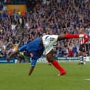 Lomana LuaLua does his iconic backflip as the Fratton faithful celebrate in the background.