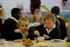 Two pupils enjoying toast at a primary school breakfast club
