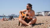 Hot weather pictures in Southsea, Portsmouth 

Pictured: Ian Jemison on the beach playing his guitar

Picture: Jack Oliver