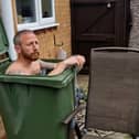 Martin Lynch taking a cold water bath in his wheelie bin