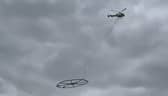 Helicopter carrying large metal circle.