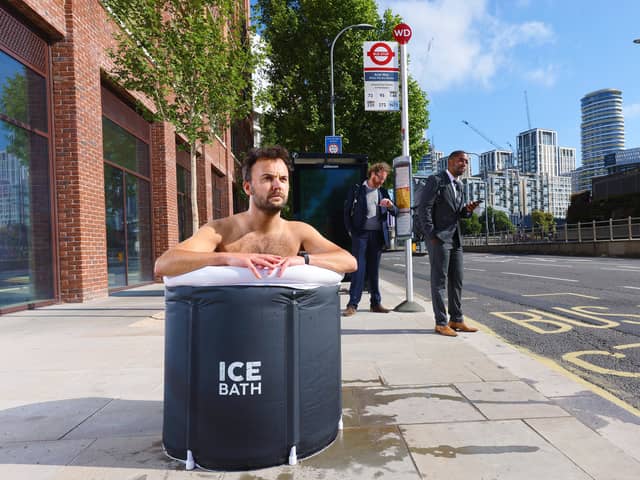 A commuter takes an ice bath at a London bus stop