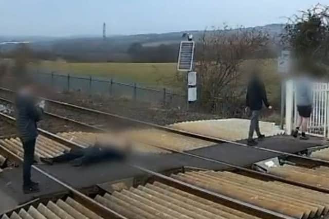 Man lies down on level crossing for photo in Barnsley, South Yorkshire.